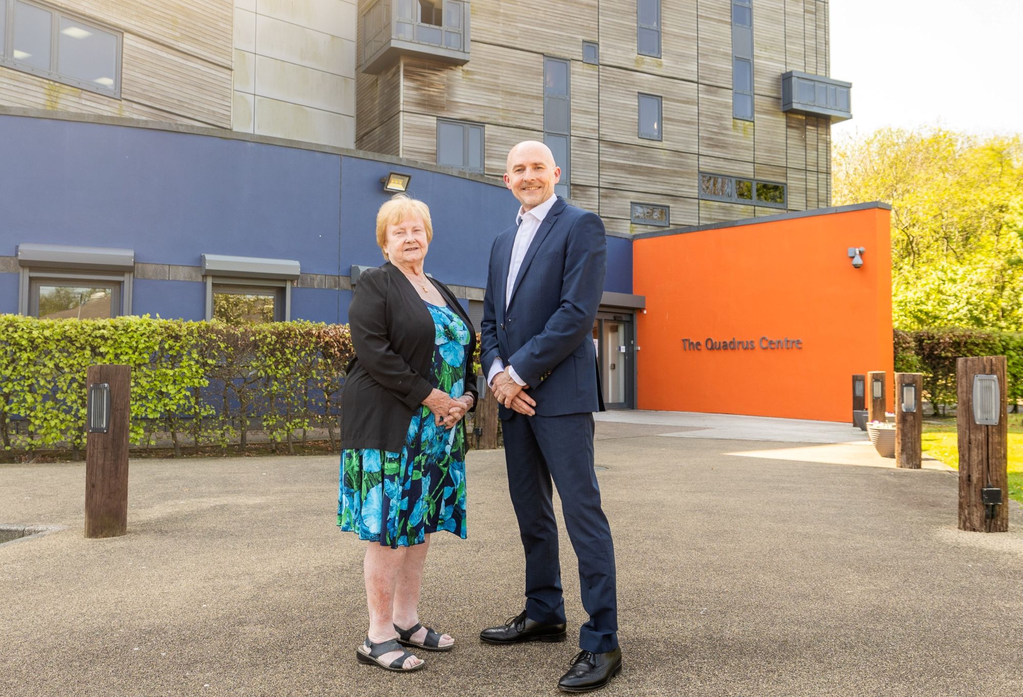 businesswomen and businessman in front of new building